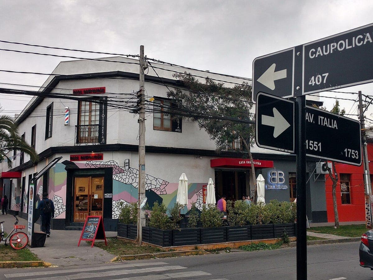 A corner café with murals at Avenida Italia and Caupolicán, Barrio Italia